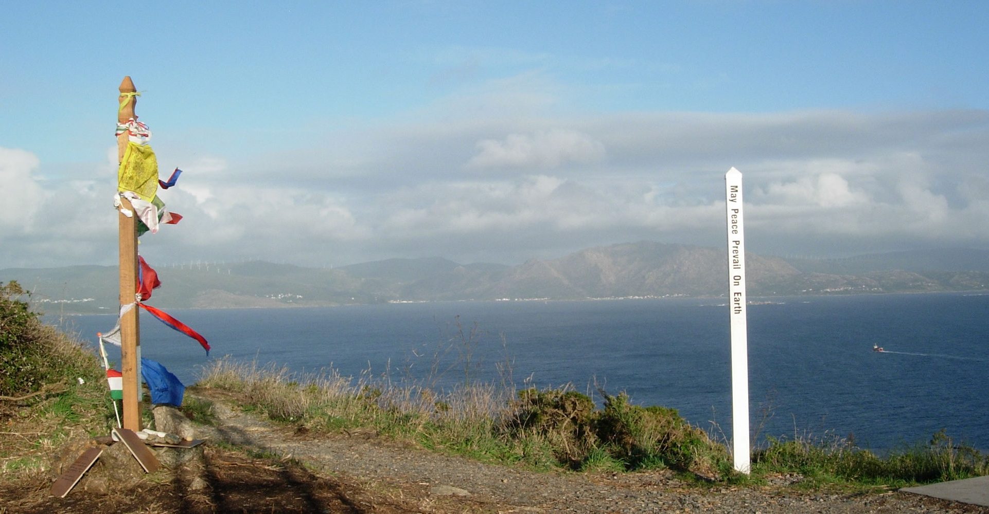 Uferweg mit Blick über das Meer. Im Hintergrund ist Land zu sehen